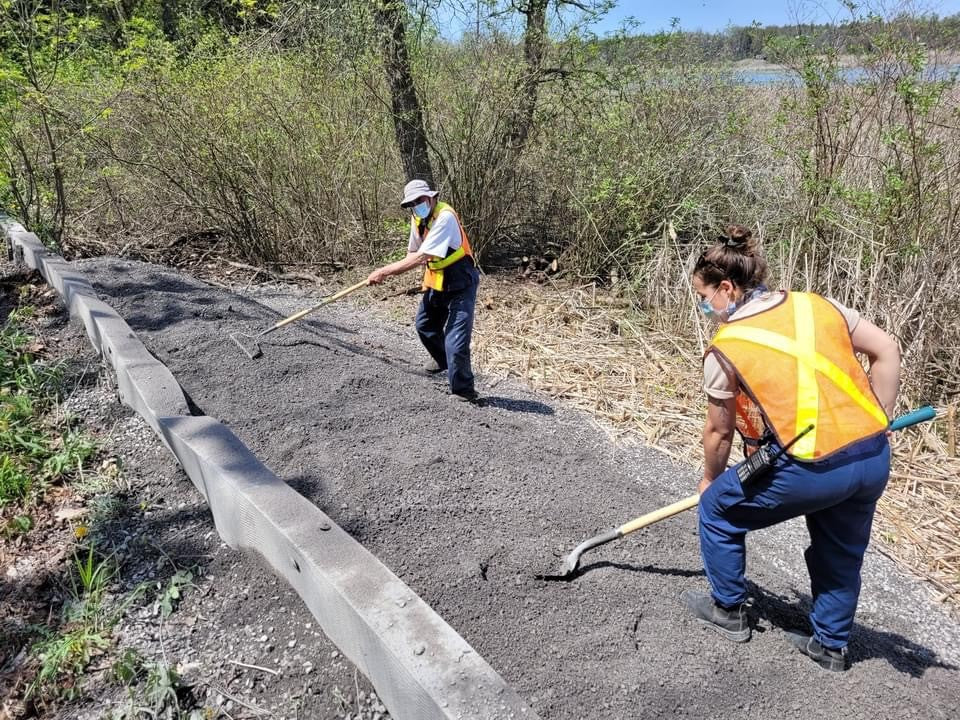Two Presqu'ile Provincial Park staff spread gravel at turtle nesting mounds.