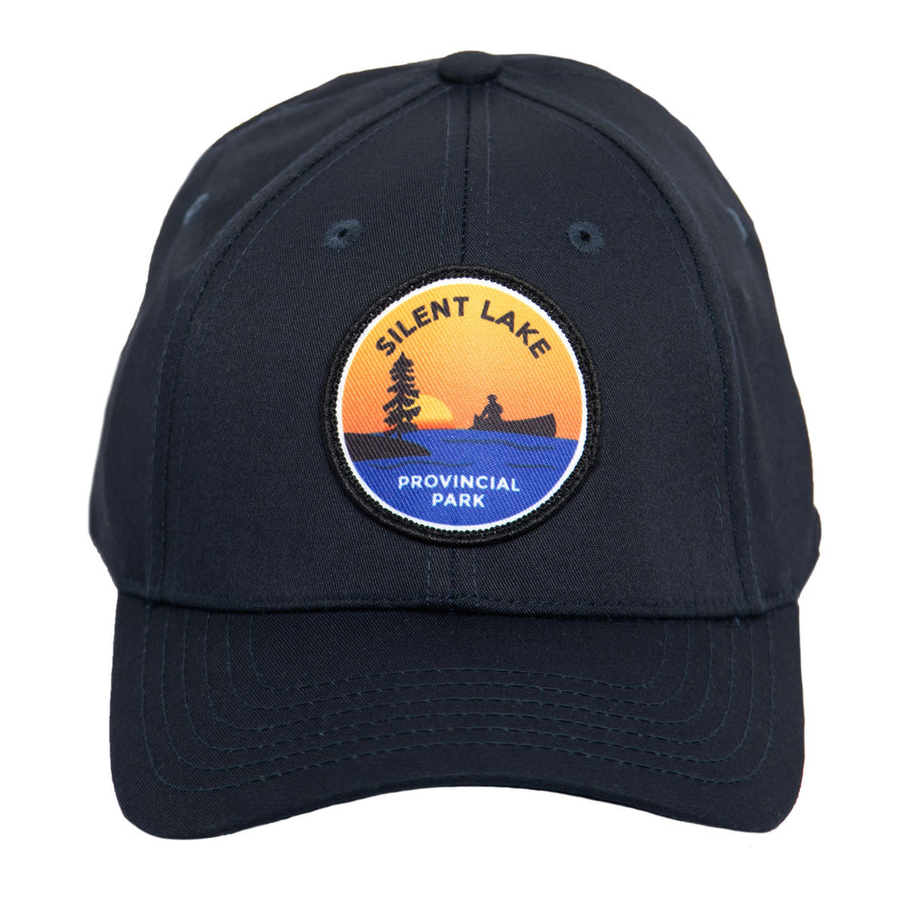 Navy park specific ball cap, featuring embroidered Silent Lake Provincial Park crest. Front view of brim. 