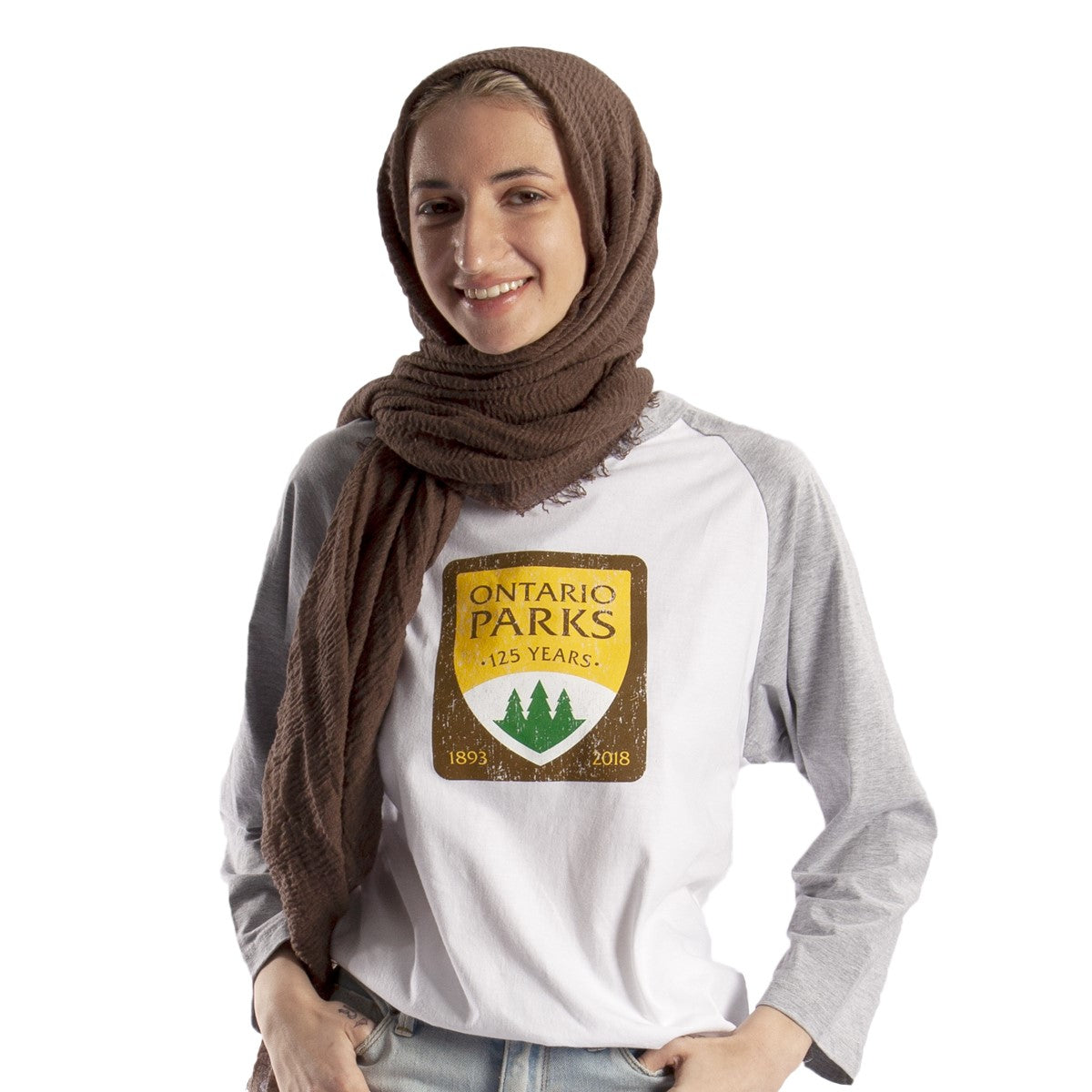 Female wearing OP125 Baseball Shirt, white shirt with grey 3/4 length sleeves. Brown/yellow original Ontario Parks logo screened on centre chest. 