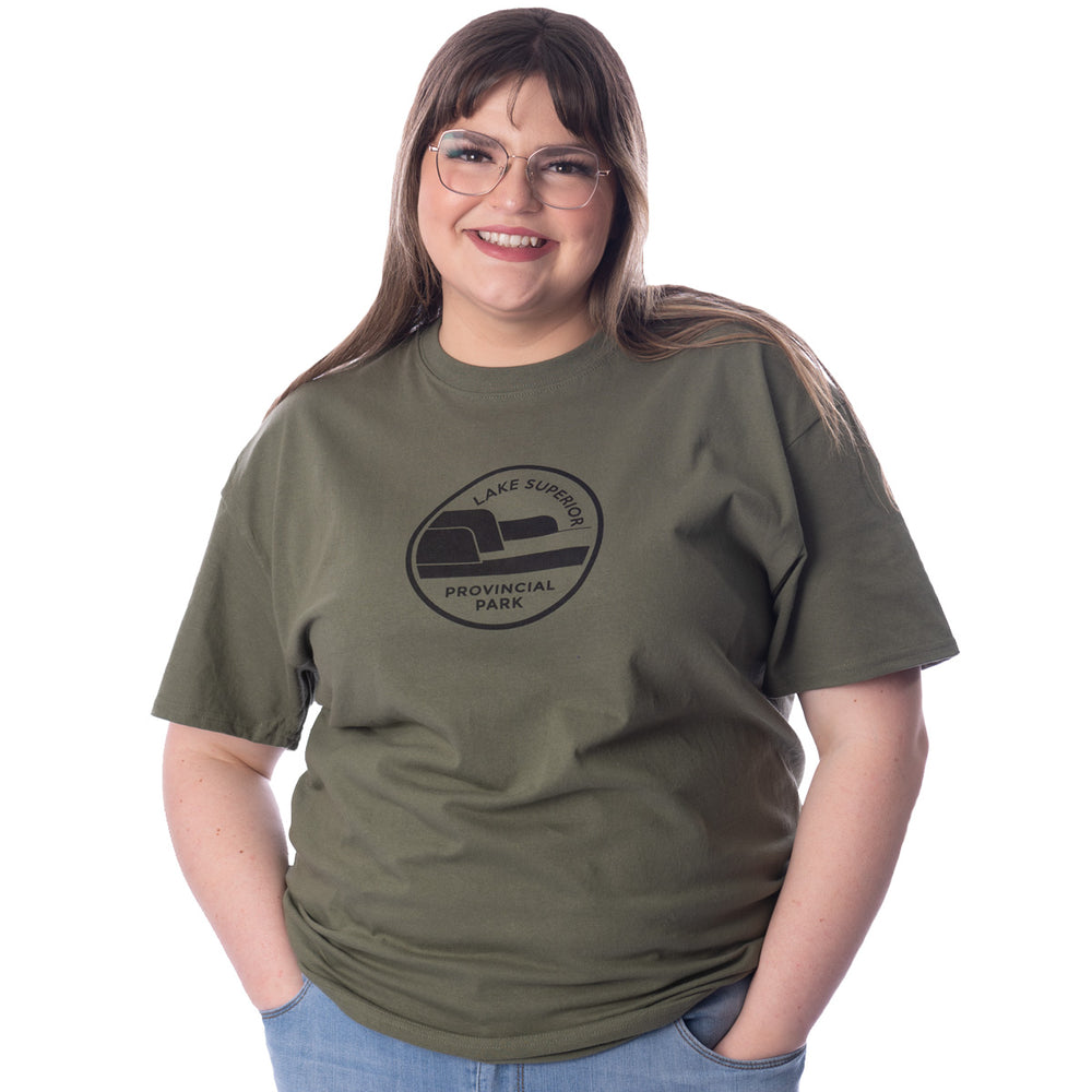 Female wearing Fatigue Green Unisex Park Specific T-shirt. Black Lake Superior park crest on centre chest.