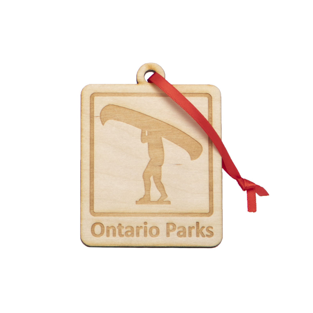 Wooden Ontario Parks square holiday ornament, showing etched graphic of Portage icon. Hung on red ribbon.