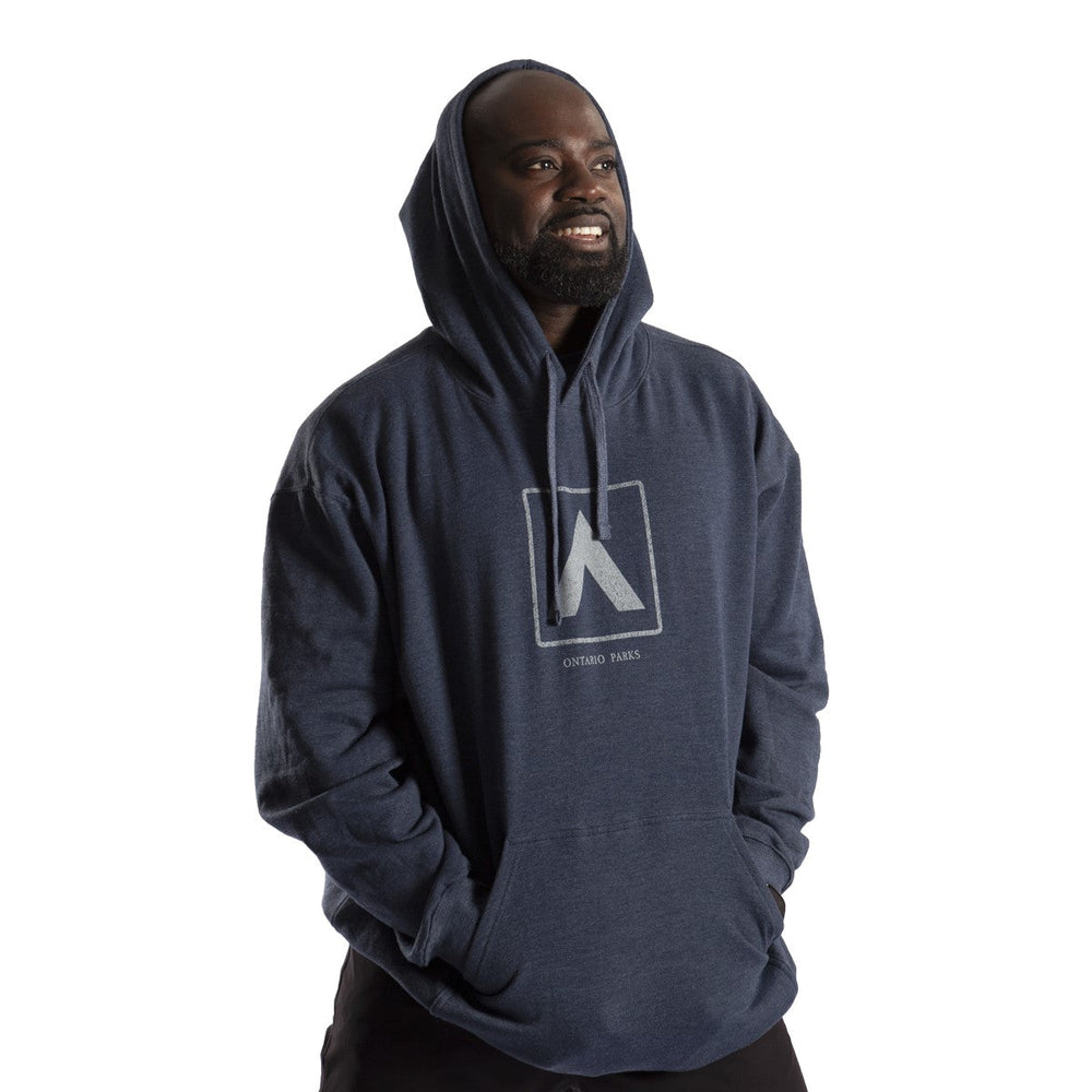 Male wearing heather navy Unisex Tent Hoody. Light blue tent graphic screened on centre chest.